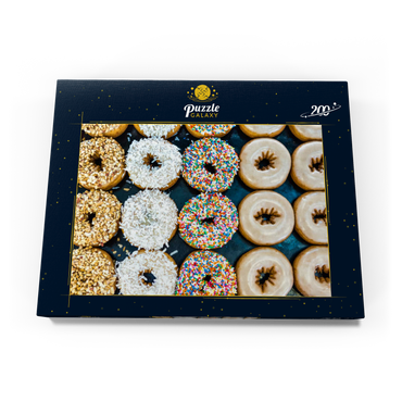 Darstellung des Puzzle Motivs Frische Donuts mit verschiedenen Belägen aus der örtlichen Bäckerei. 200 Puzzle Schachtel Ansicht3