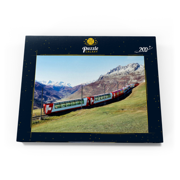 Ein Express mit Panoramafenstern und Blick auf die Wiesen auf den Bergen und schneebedeckten Bergen unter blausonnigem Himmel in Andermatt, Uri, Schweiz 200 Puzzle Schachtel Ansicht3